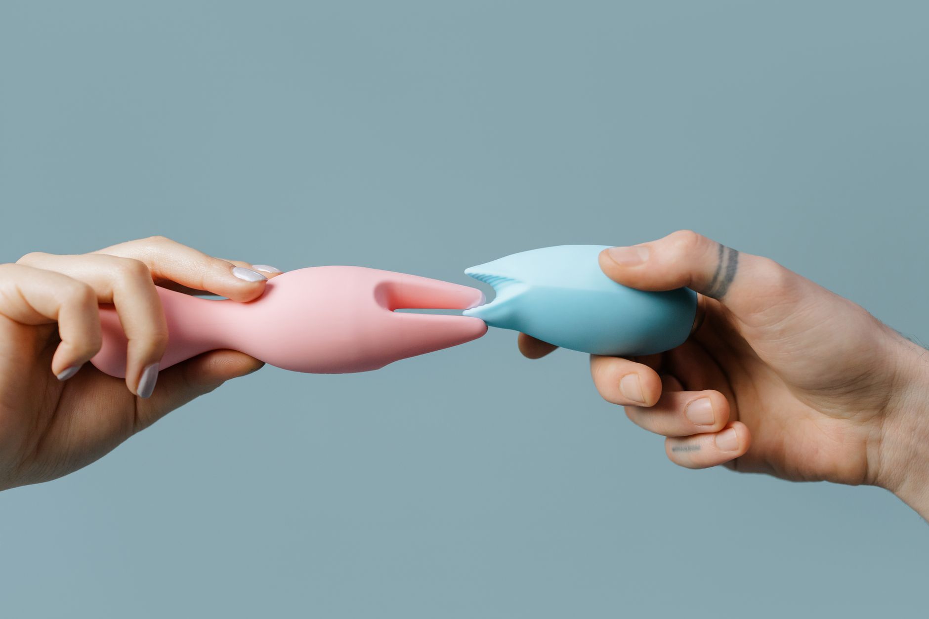 Hands holding colorful silicone vibrators, symbolizing intentional pleasure practices in your 30s