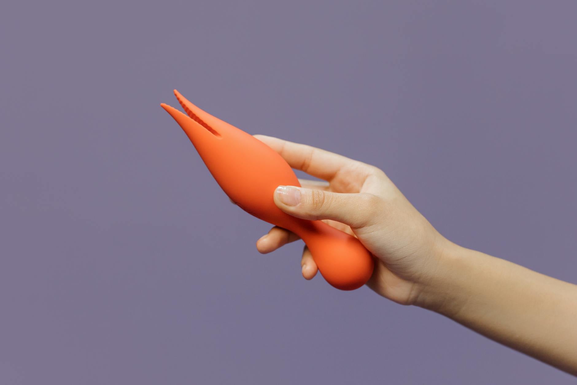 Woman holding a vibrator with a thoughtful expression, representing the confidence and openness of introducing a toy to a partner